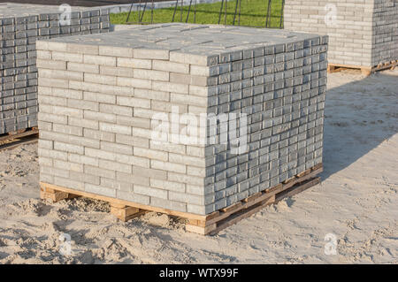 Paving grey slabs fot pavement construction in city. Gray concrete paving slabs on sand bedding to level for laying granite paver blocks Stock Photo