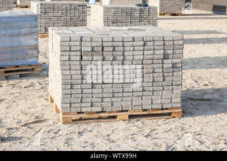 Paving grey slabs fot pavement construction in city. Gray concrete paving slabs on sand bedding to level for laying granite paver blocks Stock Photo