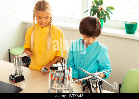 Schoolchildren building robots during their science class. Stock Photo