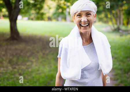 Portrait of smiling sporty senior woman outdoor Stock Photo