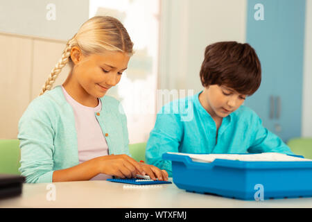 Girl building a house during her school lesson. Stock Photo