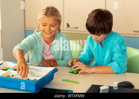 Classmates building figures during their school lesson. Stock Photo