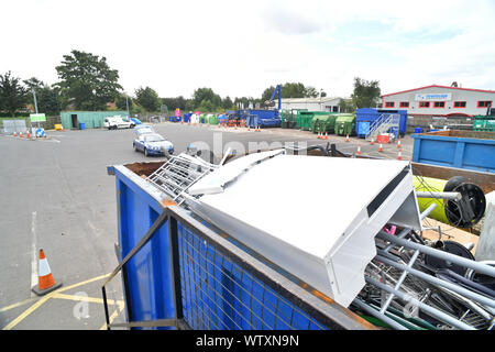 man putting scrap metal into skip for recycling at household waste recycling centre united kingdom Stock Photo