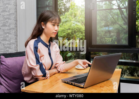 Young businesswoman point to laptop while sitting in home office, freelance concept. Stock Photo