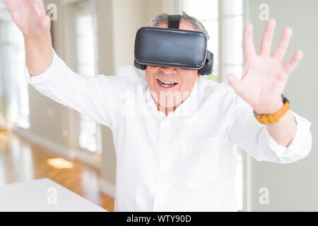 Man wearing virtual reality glasses smiling looking very happy and excited Stock Photo