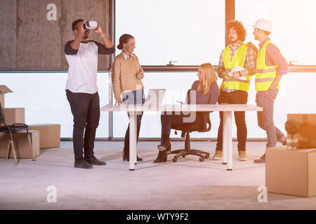 young multiethnic business team checking documents and business workflow on construction site using the virtual reality headset and laptop computer wi Stock Photo