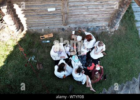 Grodzisko Owidz, Starogard Gdański 08/25/2019 members of a historical reenactment group in medieval slavic clothes resting in shade at Museum of Slavi Stock Photo