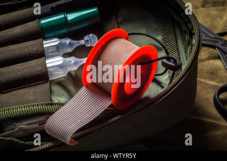 Pocket military outdoor first aid kit on khaki canvas background Stock Photo