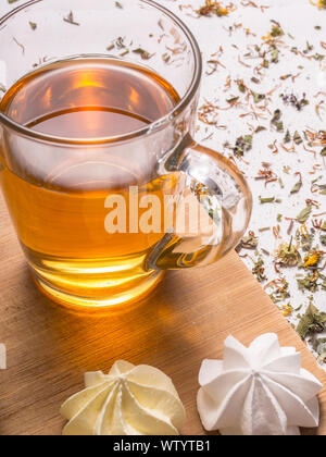 Still life with healthful herbal tea, sweets and wooden cutting board on white background Stock Photo