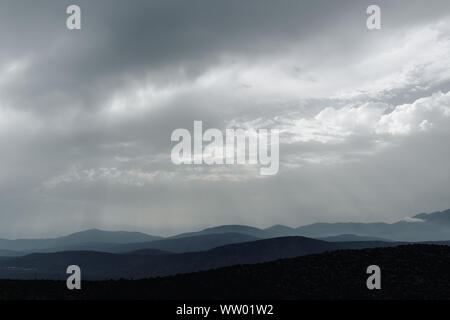 Spectacular blue and cyan mountain ranges silhouettes. Dramatic overcast sky. Delphi, Greece Stock Photo