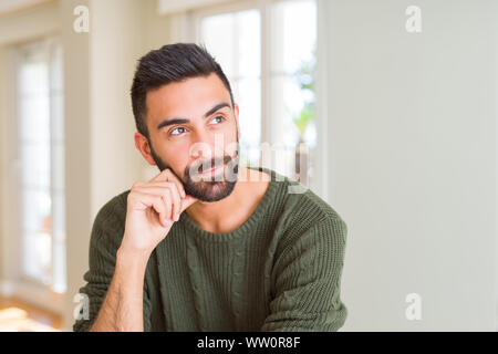 Handsome man thinking confused about doubt, questioning an idea Stock Photo