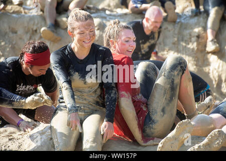 Two girls on the ‘Mud Mile’ at the Tough Mudder endurance event in Badminton Park, Gloucestershire UK Stock Photo