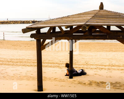 Tel Aviv, Israel - February 4, 2017: Woman relaxing on the beach Tel Baruch in Tel Aviv. Stock Photo