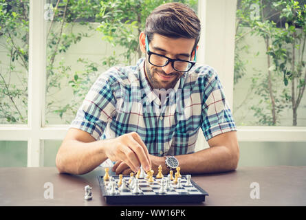 Casual businessman playing chess game with retro style photo, in business competition and planning strategies concept. Stock Photo