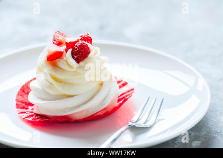 One beautiful individual Pavlova dessert on a white plate. Close up. Stock Photo