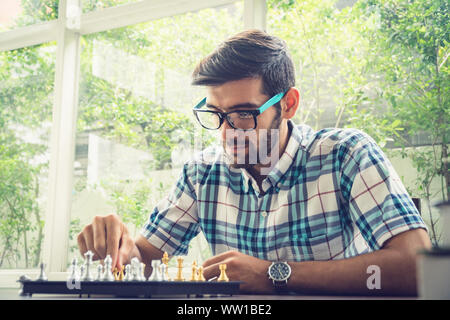 Casual businessman playing chess game with retro style photo, in business competition and planning strategies concept. Stock Photo