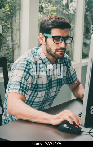 Good looking young business man working on the internet at home Stock Photo