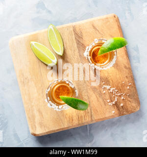 Golden tequila shots with lime slices and salt rims, overhead square shot Stock Photo