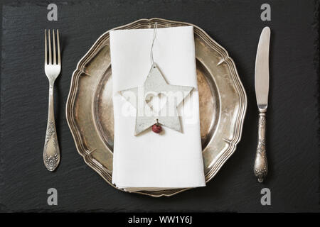 Christmas table setting with vintage dishware, silverware and star decorations. Top view. Christmas decorations. Stock Photo