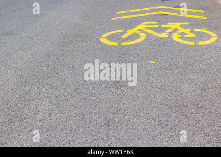 Yellow bicycle cycle track sign painted on asphalt street, Sopron, Hungary Stock Photo