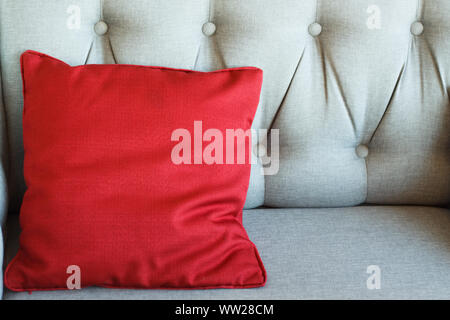 Close up of a carriage tie on a leather sofa and red pillow, background or concept, selective focus Stock Photo