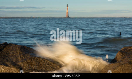 Morris Point lighthouse in the sea with waves crashing over rocks. Stock Photo