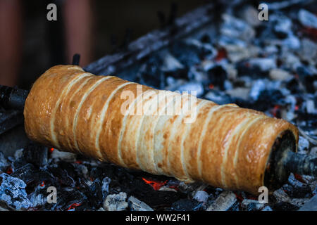 Preparation of the famous, traditional and delicious Hungarian Chimney Cake Kurtos Kolacs (Kürtőskalács) Stock Photo