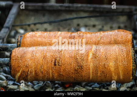 Preparation of the famous, traditional and delicious Hungarian Chimney Cake Kurtos Kolacs (Kürtőskalács) Stock Photo