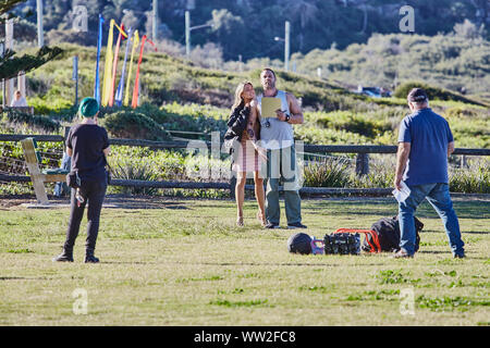 Actors Jake Ryan and Sam Frost plus a member of the filming cast prepare to film an outdoor scene of Home & Away tv series at Palm Beach, Australia Stock Photo
