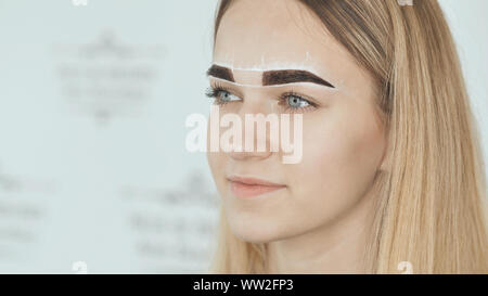 Create permanent eyebrow makeup. Marking the shape of the eyebrows. Stock Photo