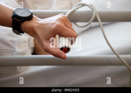 A hand holding emergency button in hospital room, AF point selection and blured. Stock Photo