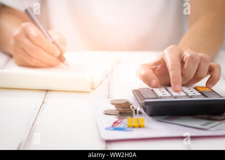 businesswoman using a calculator on desk, Choose focus point. In over light. Stock Photo