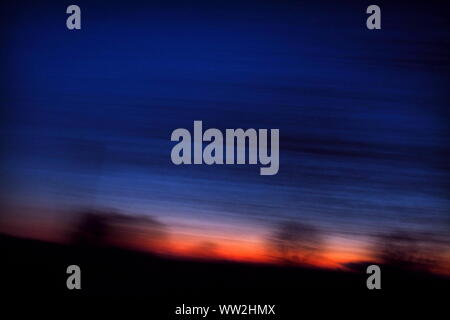 red and blue sunrise background, blurred landscape, feeling of motion and speed Stock Photo