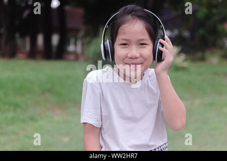 A girl listening to music by the white headphone Stock Photo