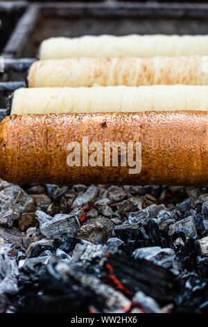 Preparation of the famous, traditional and delicious Hungarian Chimney Cake Kurtos Kolacs (Kürtőskalács) Stock Photo