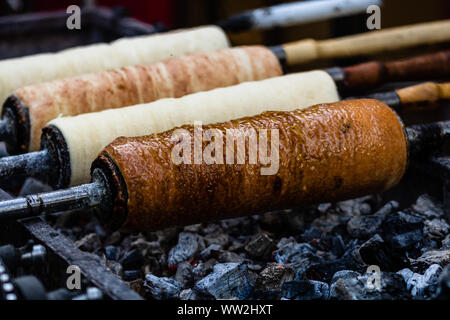 Preparation of the famous, traditional and delicious Hungarian Chimney Cake Kurtos Kolacs (Kürtőskalács) Stock Photo