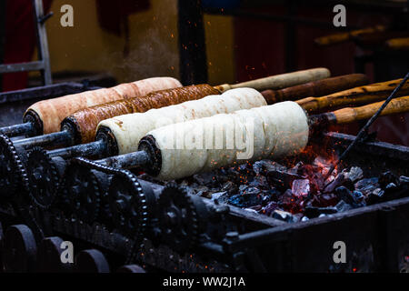 Preparation of the famous, traditional and delicious Hungarian Chimney Cake Kurtos Kolacs (Kürtőskalács) Stock Photo