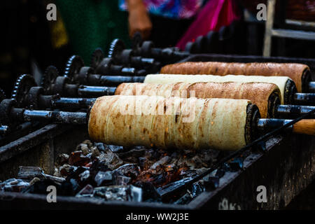 Preparation of the famous, traditional and delicious Hungarian Chimney Cake Kurtos Kolacs (Kürtőskalács) Stock Photo