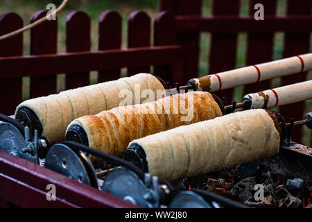 Preparation of the famous, traditional and delicious Hungarian Chimney Cake Kurtos Kolacs (Kürtőskalács) Stock Photo