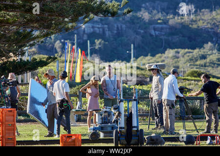 Actors Jake Ryan and Sam Frost plus a member of the filming cast prepare to film an outdoor scene of Home & Away tv series at Palm Beach, Australia Stock Photo