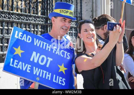 Westminster, London, UK. 12th Sep, 2019. A passer-by takes a selfie with 'Stop Brexit Man' Steven Bray, also known as Westminster's 'Stop Brexit Man'. Anti-Brexit protesters from SODEM (Stand of Defiance European Movement) rally with placards and flags outside the main gates at Parliament today. Credit: Imageplotter/Alamy Live News Stock Photo