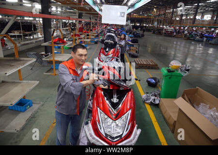Chinese factory workers assemble electric bikes on the assembly line at ...
