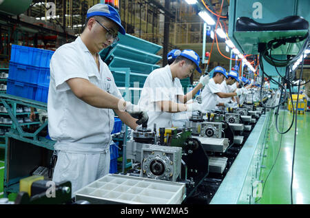 Chinese factory workers assemble motorcycles on the assembly line at the plant of Sundiro Honda Motorcycle Co., Ltd. in Taicang City, east China's Jia Stock Photo