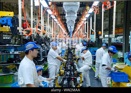 Chinese factory workers assemble motorcycles on the assembly line at the plant of Sundiro Honda Motorcycle Co., Ltd. in Taicang City, east China's Jia Stock Photo