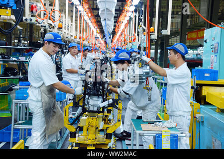 Chinese factory workers assemble motorcycles on the assembly line at the plant of Sundiro Honda Motorcycle Co., Ltd. in Taicang City, east China's Jia Stock Photo