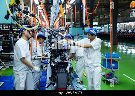 Chinese factory workers assemble motorcycles on the assembly line at the plant of Sundiro Honda Motorcycle Co., Ltd. in Taicang City, east China's Jia Stock Photo