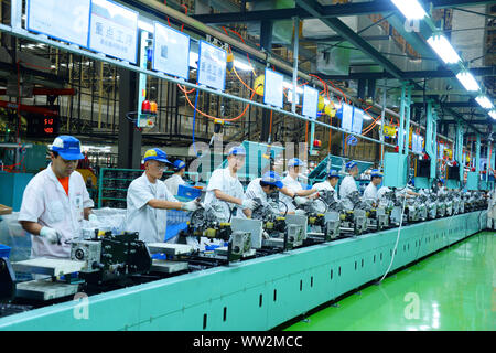 Chinese factory workers assemble motorcycles on the assembly line at the plant of Sundiro Honda Motorcycle Co., Ltd. in Taicang City, east China's Jia Stock Photo