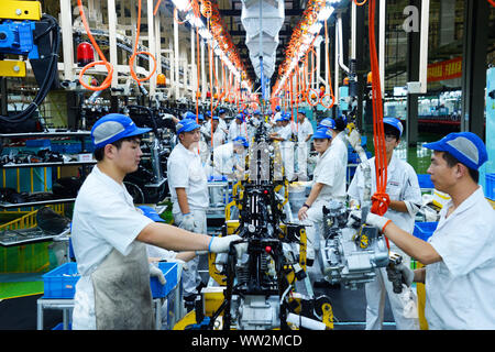 Chinese factory workers assemble motorcycles on the assembly line at the plant of Sundiro Honda Motorcycle Co., Ltd. in Taicang City, east China's Jia Stock Photo