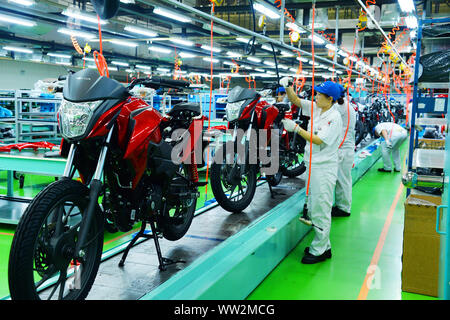 Chinese factory workers assemble motorcycles on the assembly line at the plant of Sundiro Honda Motorcycle Co., Ltd. in Taicang City, east China's Jia Stock Photo