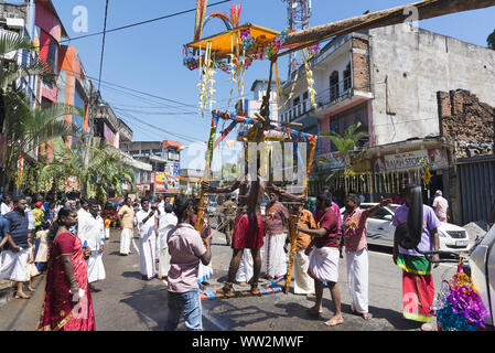 Pussellawa, Sri Lanka,  03/20/2019: Hindu festival of Thaipusam - body piercing rituals under the blood moon. Man hanging from skin. Stock Photo